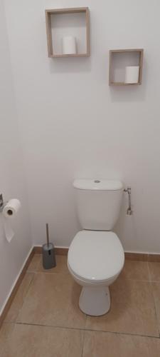a white toilet in a bathroom with two mirrors at Appartement NANA-B21-La terrasse in Cayenne