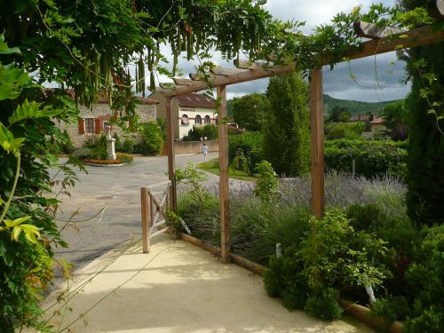a wooden pergola in a garden with flowers at Le Vinois in Caillac