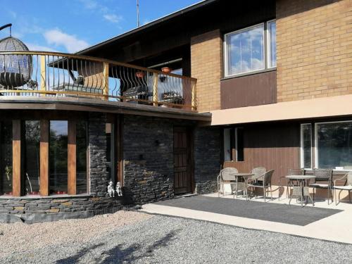 a house with a balcony with tables and chairs at Holiday Home Villa meka by Interhome in Sastamala