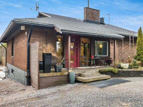 a small brick house with a red door at Holiday Home Villa meka by Interhome in Sastamala
