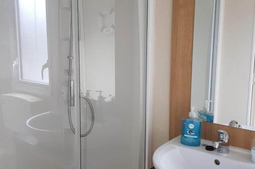a white bathroom with a shower and a sink at pool-garden-2br-parking-wifi-sleeps6 in Paignton