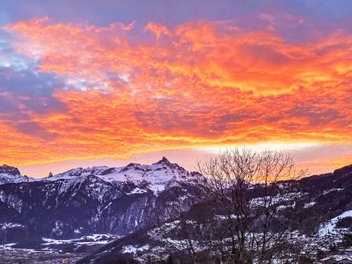 a sunset over a mountain range with snow covered mountains at Apartment Lau'tentik by Interhome in Monthey