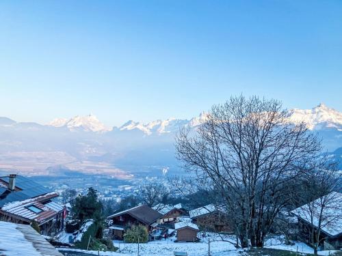a snow covered village with mountains in the background at Apartment Lau'tentik by Interhome in Monthey