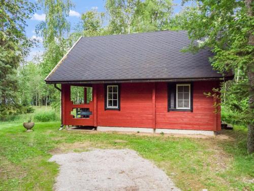 una casa rossa con un tetto nero in un cortile di Holiday Home Strandkulla 7 by Interhome a Närpiö