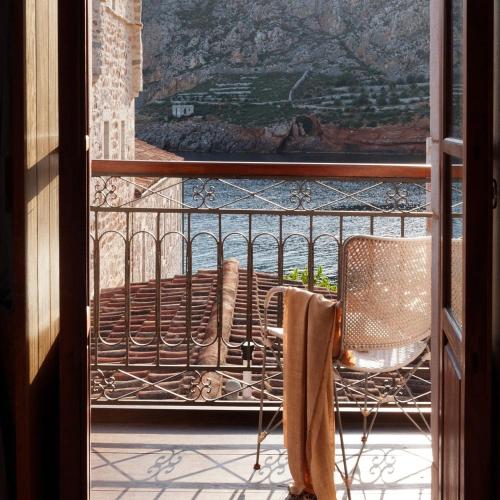 a balcony with a chair and a view of a mountain at Kyrimai Hotel in Gerolimenas