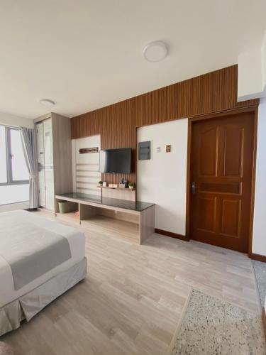 a bedroom with a bed and a desk and a television at Paralian Hulhumale' in Hulhumale