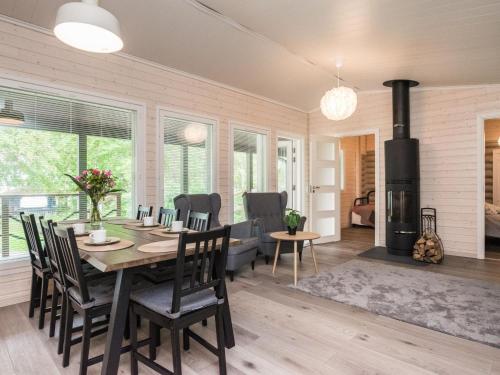 ein Esszimmer mit Tisch und Stühlen und einem Kamin in der Unterkunft Holiday Home Villa vehmas by Interhome in Sysmä
