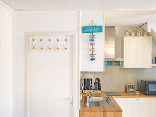 - une cuisine avec une porte blanche et un évier dans l'établissement Holiday Home La Plagette by Interhome, à Aigues-Mortes