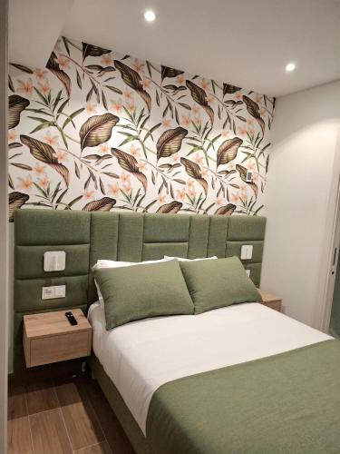 a bedroom with a bed with a floral wall at Hostal San Blas in Madrid