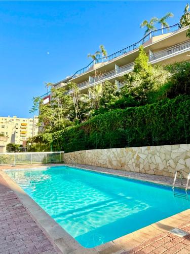une piscine devant un immeuble dans l'établissement Cosy Studio Sunny Terrace and Pool Next to the Beach and Monaco, à Roquebrune-Cap-Martin