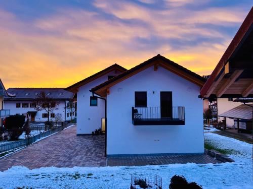 a white house with a sunset in the background at Ferienwohnung Kamml in Waging am See