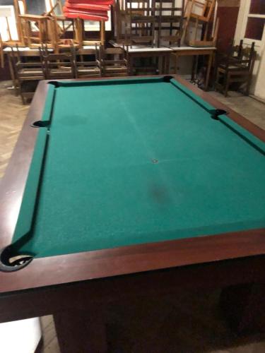 a green pool table in a room with chairs at Hostinec U PUDILŮ in Soběšín