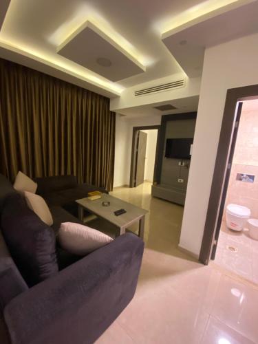 a living room with a couch and a table at abdoun rooftop 1bedroom kh&sh 04 in Amman