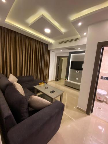 a living room with a couch and a television at abdoun rooftop 1bedroom kh&sh 04 in Amman