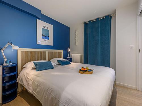 une chambre avec un grand lit avec un mur bleu dans l'établissement Apartment Village de Légenèse-6 by Interhome, à Carnac
