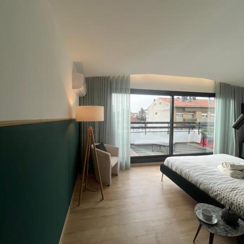 a hotel room with a bed and a large window at Vila Camélia in Porto