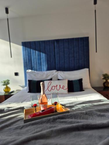 a bed with a tray with a bottle of wine and glasses at Newly Renovated Flat with Parking space in Canterbury