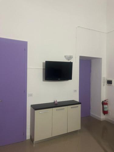 a room with a tv on the wall and a table at Angolo di Viola in Turin