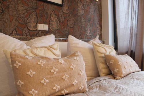 a bed with a bunch of pillows on it at Hotel Via Vita in Treuchtlingen