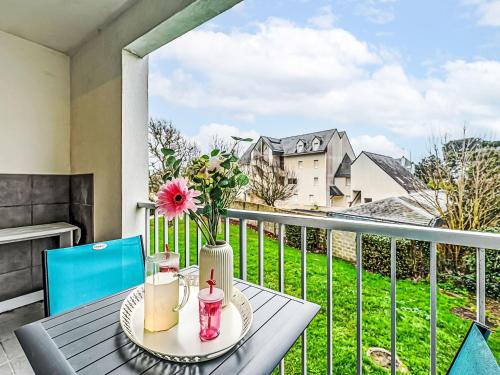 a table with a vase of flowers on a balcony at Apartment Le Zal-4 by Interhome in Quiberon