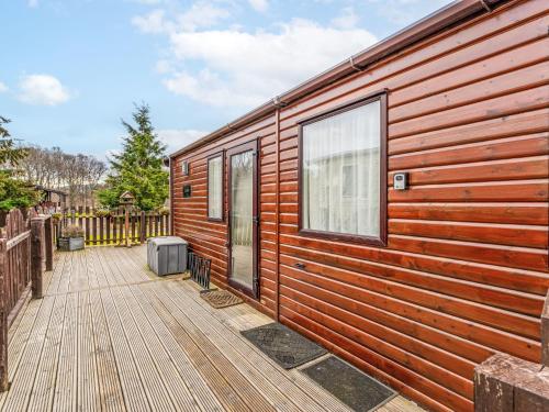 a wooden cabin with a deck and a window at Chalet Monarch by Interhome in Aviemore