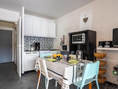 une cuisine avec une table avec des chaises et un micro-ondes dans l'établissement Apartment Les Aigues Marines-71 by Interhome, à Saint-Cyr-sur-Mer