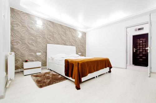 a bedroom with a bed with a brown blanket on it at Danube Residence in Galaţi