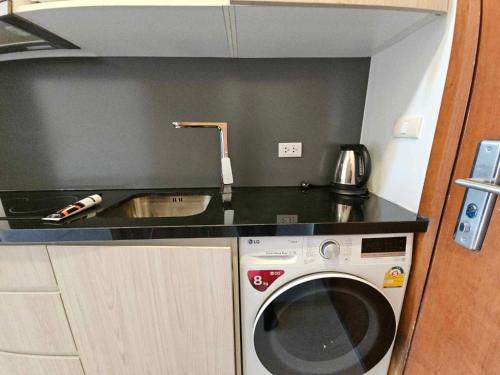 a kitchen with a washing machine and a sink at Laguna Beach Resort 2 Jomtien in Pattaya Central