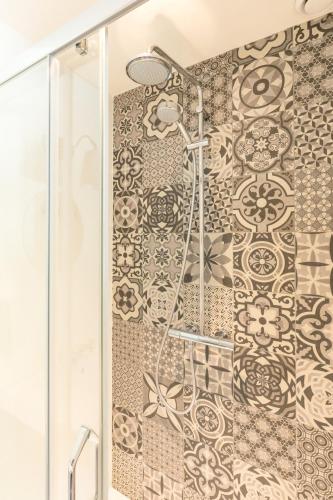 a shower in a bathroom with a tile wall at Herberg de Geulhemermolen in Berg en Terblijt