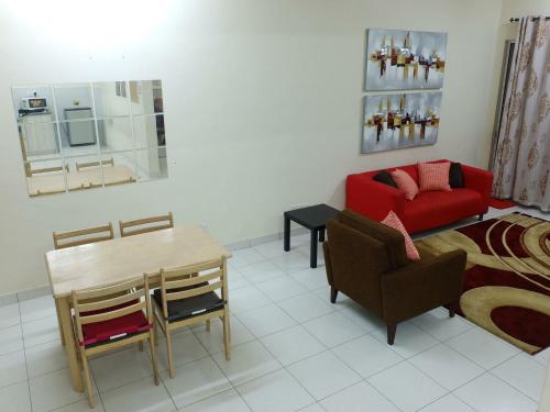 sala de estar con sofá rojo y mesa en Dillenia Nilai Homestay en Nilai