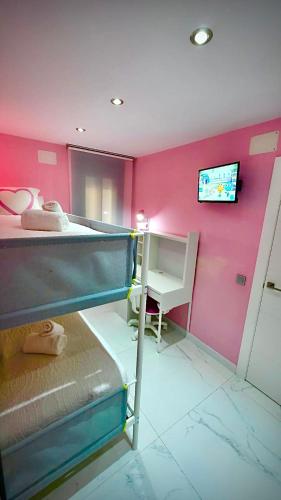 a bedroom with a bunk bed with a tv on the wall at CENTRO, PARKING, PISCINA 2 Dormitorios SUITE PONDOS in Linares