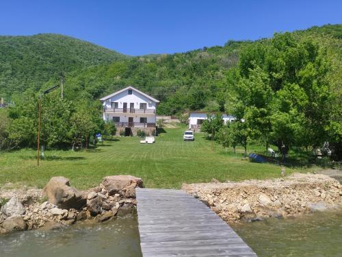 a house with a bridge over a body of water at Casa de Vacanță Golful Drencova in Drencova