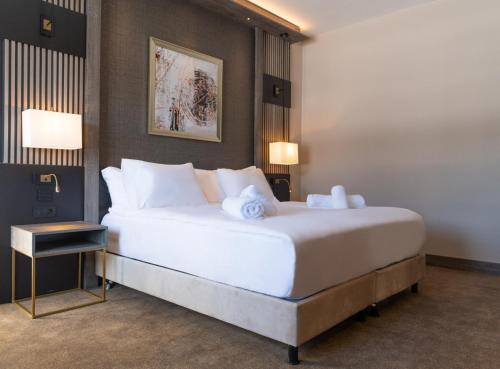 a bedroom with a large bed with white pillows at Doubletree By Hilton Kars Sarikamis in Sarıkamıs