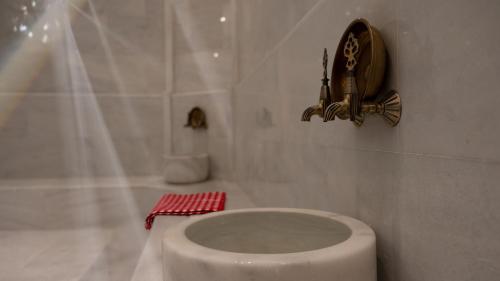 a white bathroom with a toilet and a sink at Doubletree By Hilton Kars Sarikamis in Sarıkamıs