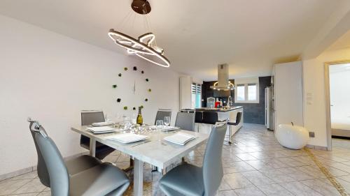une salle à manger avec une table et des chaises blanches dans l'établissement Chez Ludivine - Maison avec Terrasse et Parking, à Orbey
