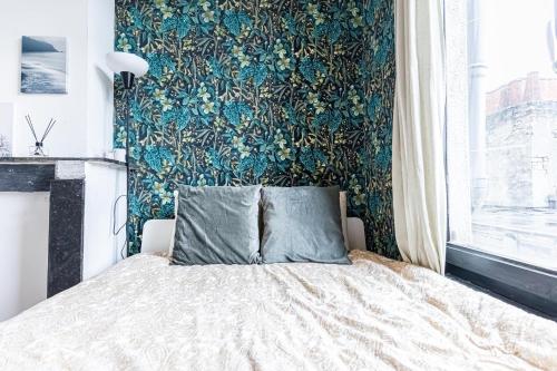 a bedroom with a bed with a floral wallpaper at Lovely & Comfortable Studio Apartments at Heart of Gent in Ghent