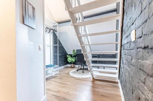 a staircase in a living room with a brick wall at Lovely & Comfortable Studio Apartments at Heart of Gent in Ghent