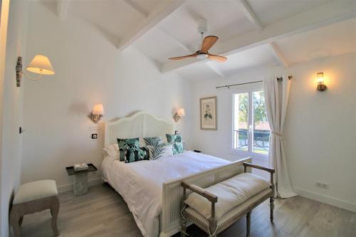 une chambre avec un lit et un ventilateur de plafond dans l'établissement Maison dans les Arbres PISCINE CLIM Luxe, à Hyères