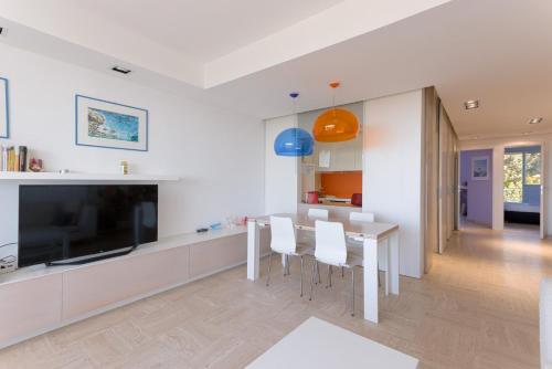 une cuisine et une salle à manger avec une table et une télévision dans l'établissement The Horizon – Sea View & Peaceful Retreat, à Cannes