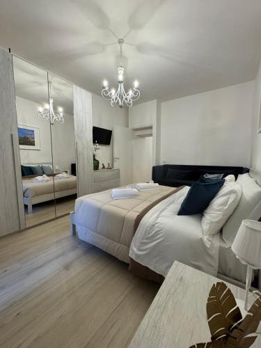 a bedroom with a large bed and a chandelier at Palazzo Monterone Apartments in Spoleto