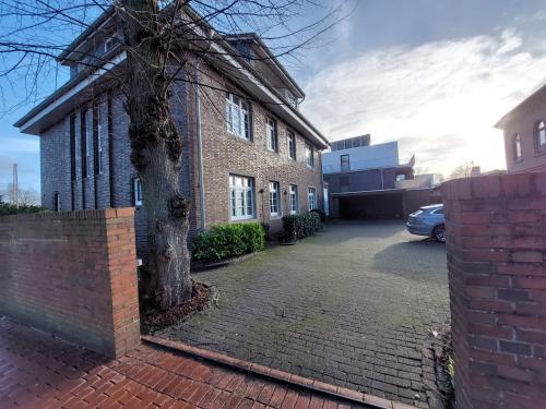 a brick building with a tree in front of it at maremar - Design-Maisonette am Holzmarkt - Luxus Boxspringbetten - Arbeitsplatz - Loggia in Verden