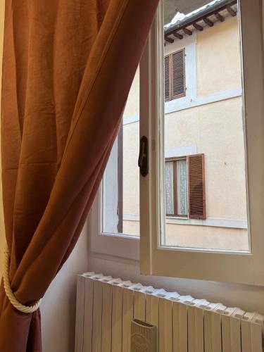 a window with a curtain and a radiator in a room at Palazzo Monterone Apartments in Spoleto