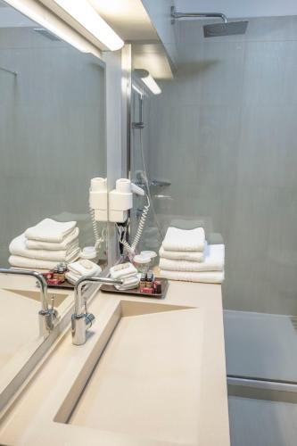 a bathroom with a sink and a mirror at Hotel Pietroasa in Buzau