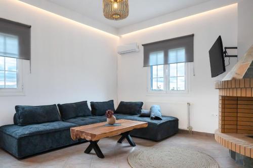 Noho Villas @ Sunlit house Paros في Nea Cryssi Akti: غرفة معيشة مع أريكة وطاولة قهوة