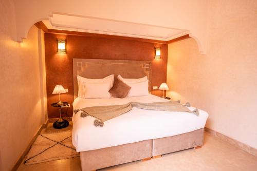 a bedroom with a large bed with white sheets at Palais Menzah & SPA in Marrakech