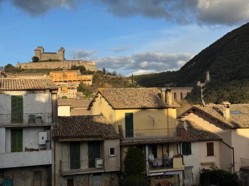 a group of buildings with a castle in the background at Palazzo Monterone Apartments in Spoleto