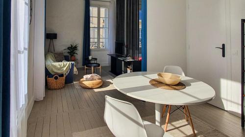 un salon avec une table et des chaises blanches dans l'établissement Charmant studio, à Caen