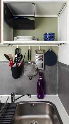 - un évier de cuisine avec une bouteille violette sur le comptoir dans l'établissement Charmant studio, à Caen