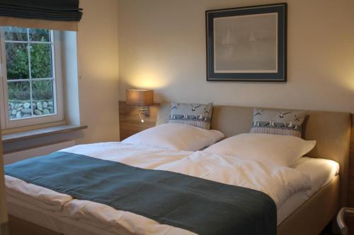 un letto grande in una camera da letto con finestra di LITZKOW 11208 a Morsum