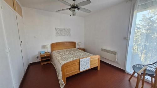 une chambre avec un lit et un ventilateur de plafond dans l'établissement RESIDENCE DU SOLEIL Spacieux T3 face à la mer au port - Parking, à Saint-Cyprien